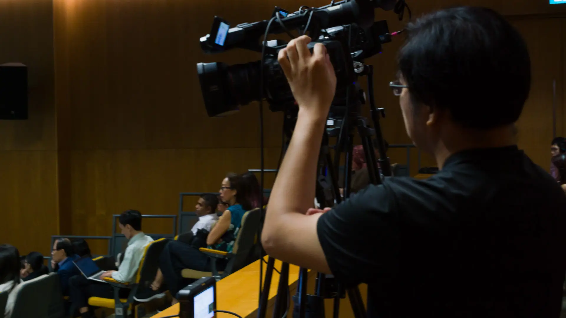 Behind-the-scenes view of a Mapletree corporate event production setup with live webcasting on custom platform, and AV crew