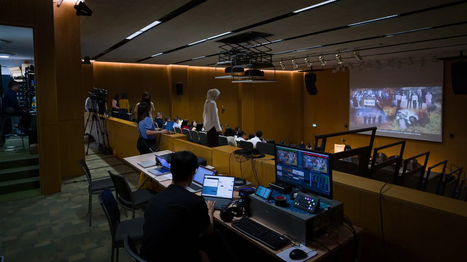 Behind-the-scenes view of a Mapletree corporate event av production setup with live streaming webcasting on custom platform, and AV crew